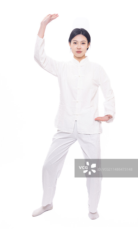 白色背景前穿着练功服做八段锦分解动作的年轻女性图片素材