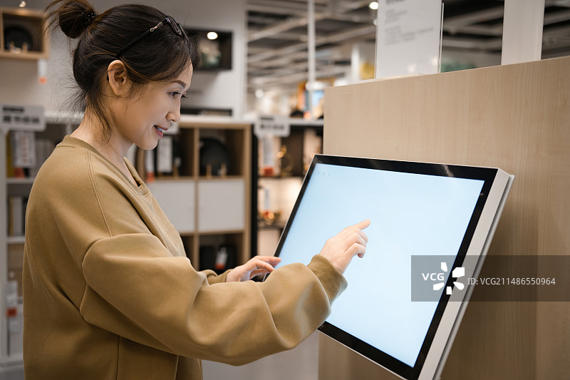 在超市购物用手指触摸产品销售目录的电子屏幕的女性图片素材