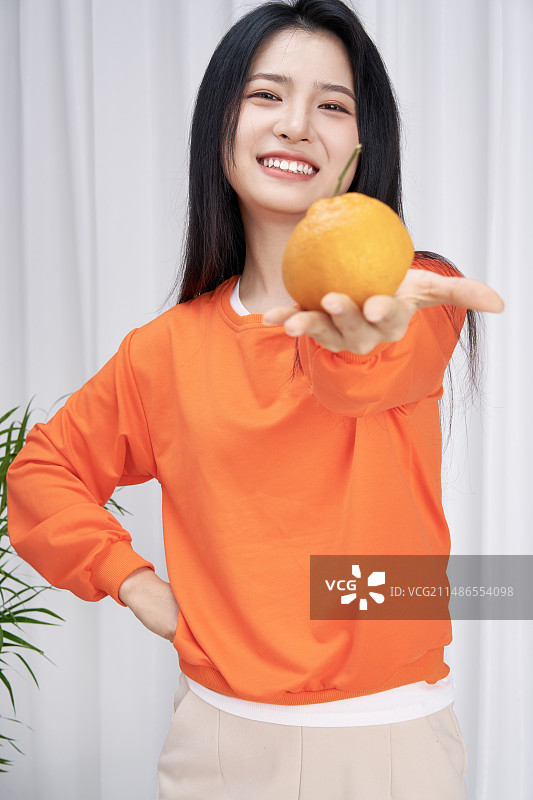 电商直播贩卖橘子的年轻女性图片素材