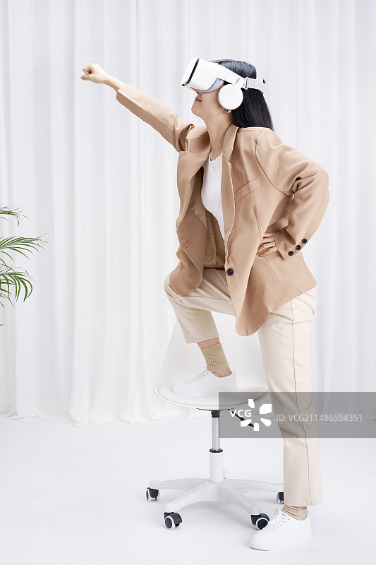 头戴VR在办公室内的年轻女孩图片素材
