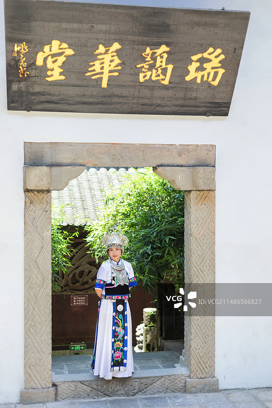 身穿蓝色白色土家族苗族服饰的中国东方女性在恩施土司城古建筑中图片素材