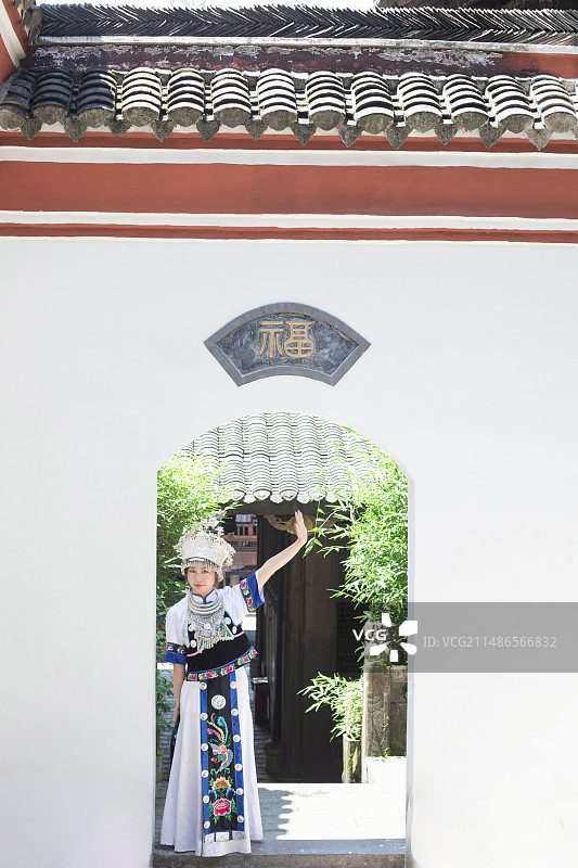 身穿蓝色白色土家族苗族服饰的中国东方女性在恩施土司城古建筑中图片素材