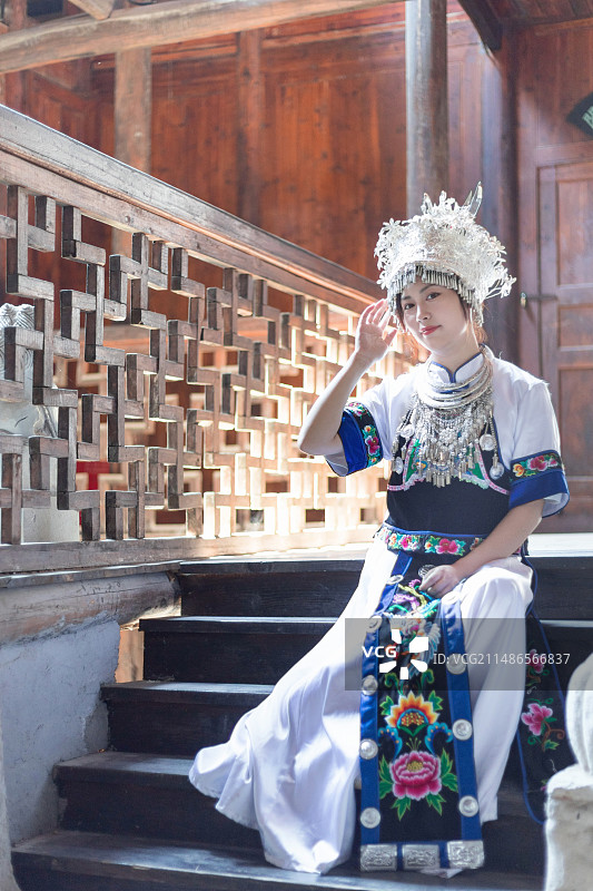 身穿蓝色白色土家族苗族服饰的中国东方女性在恩施土司城古建筑中图片素材