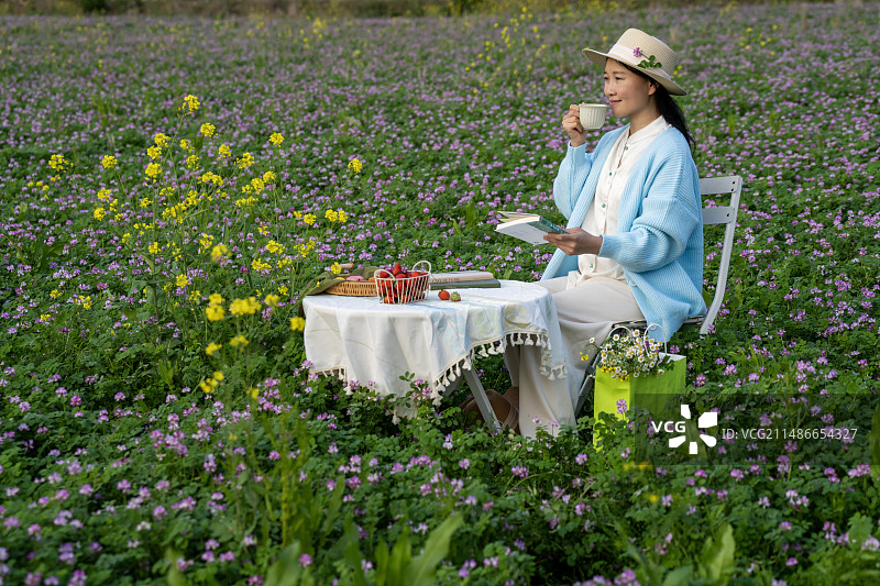 一个年轻女性在花田中间图片素材