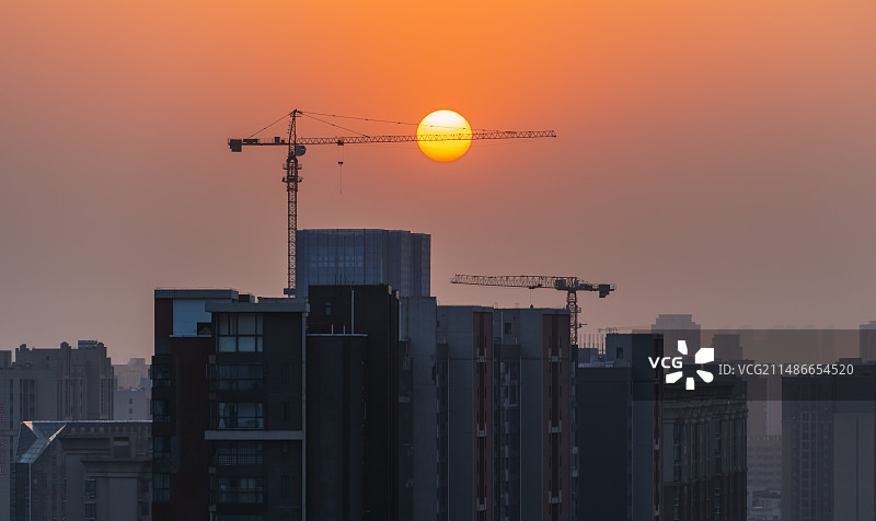 城市日落：基建工业区塔吊悬日图片素材
