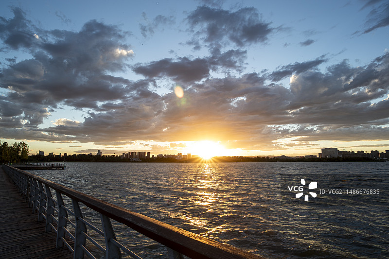 城市人工湖栏杆处日落晚霞风光图片素材
