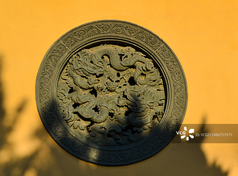 寺院黄墙上的圆形中国龙形雕刻 湖州南浔古镇广惠宫黄大仙庙 张王庙图片素材