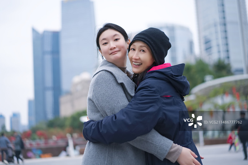 朋友在城市环境中分享快乐的拥抱图片素材