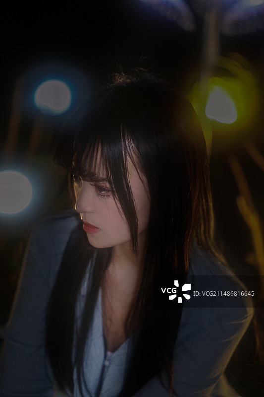花园灯光中的蓝衣女孩图片素材