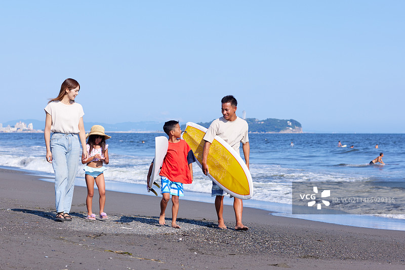 一家人在海滩上带着冲浪板图片素材