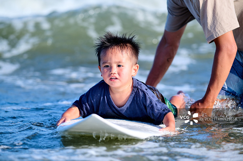 一个男孩在冲浪板上图片素材