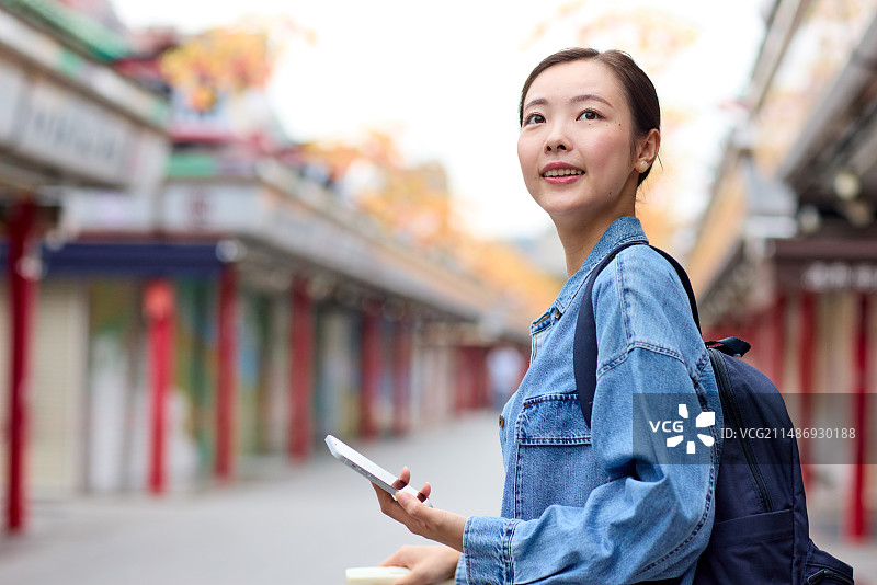 背着背包在寺庙街的亚洲女人图片素材