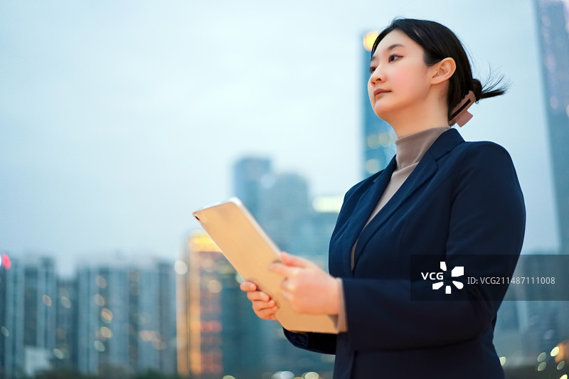 在城市环境中使用平板电脑的职业女性图片素材