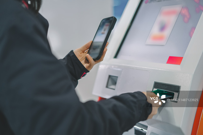 女人使用智能手机办理自动柜员机银行服务图片素材