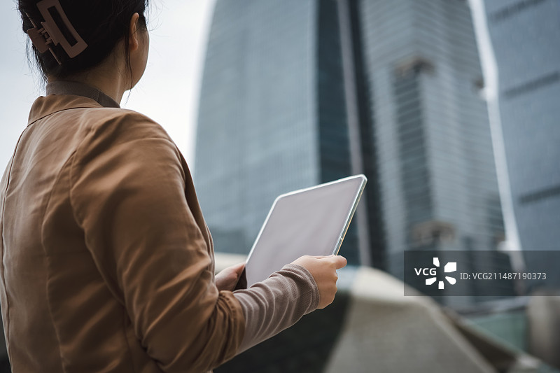 职业女性带着手机和笔记本电脑走路图片素材