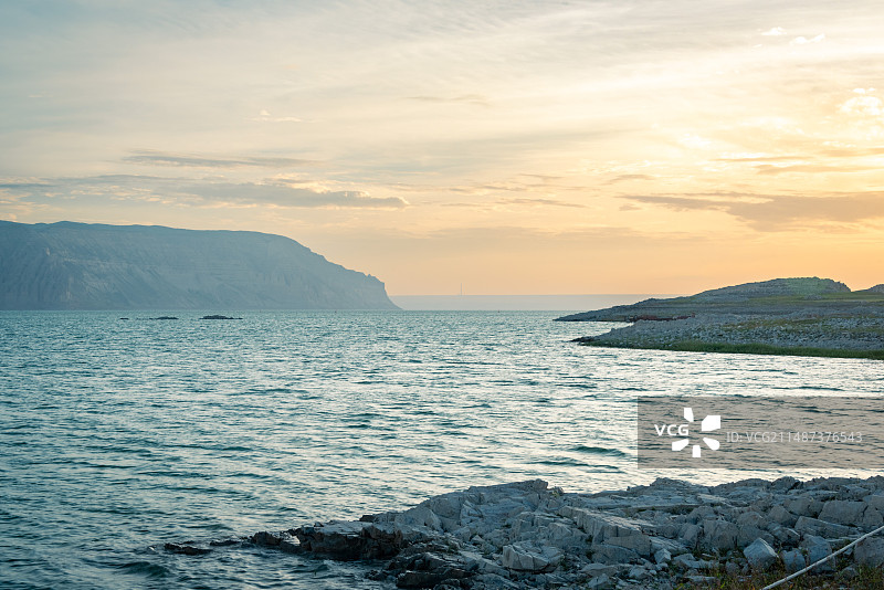 日落时分天空出现五彩晚霞，温暖的夕阳照射到黄河上游的龙羊峡电站上，黄河水碧绿清澈，黄土丘壑被夕阳照亮图片素材