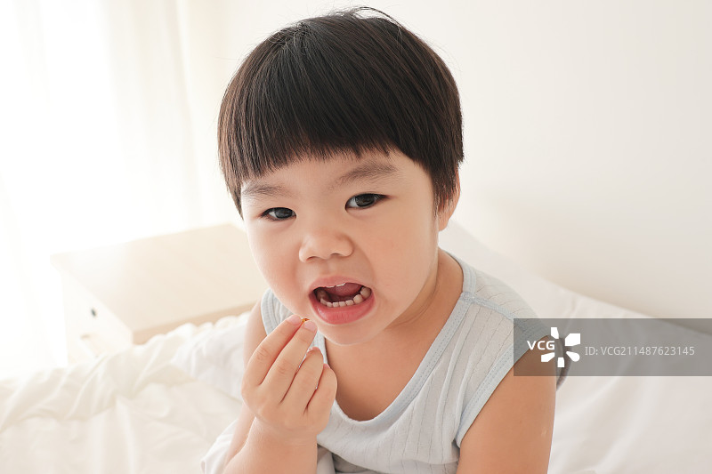 一个中国小女孩在吃维生素图片素材