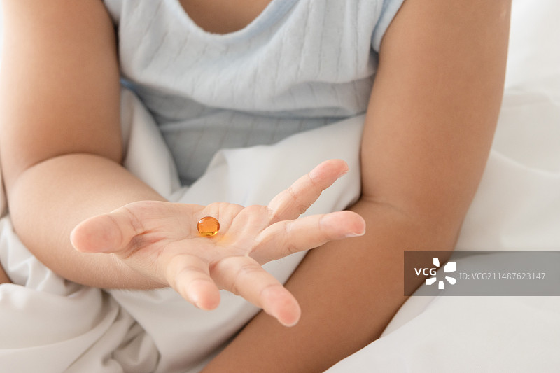 一个中国小女孩在吃维生素图片素材