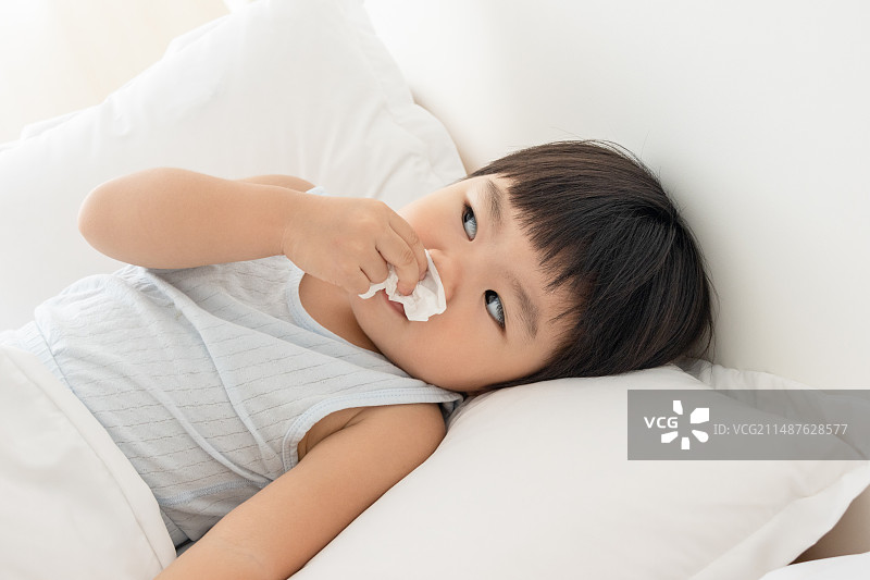 一个生病感冒的小女孩躺在床上图片素材