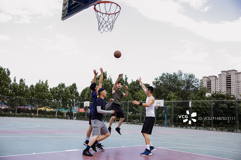 四个青年男子在学校篮球场打篮球比赛图片素材