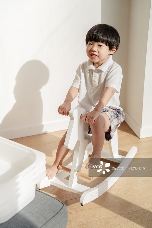 骑白木马的快乐小男孩图片素材