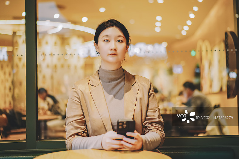 年轻女子在舒适的咖啡馆使用智能手机图片素材