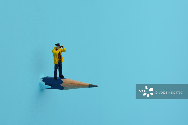 站在穿透彩色卡纸铅笔上拿望远镜看这远方的男士微缩创意图片素材