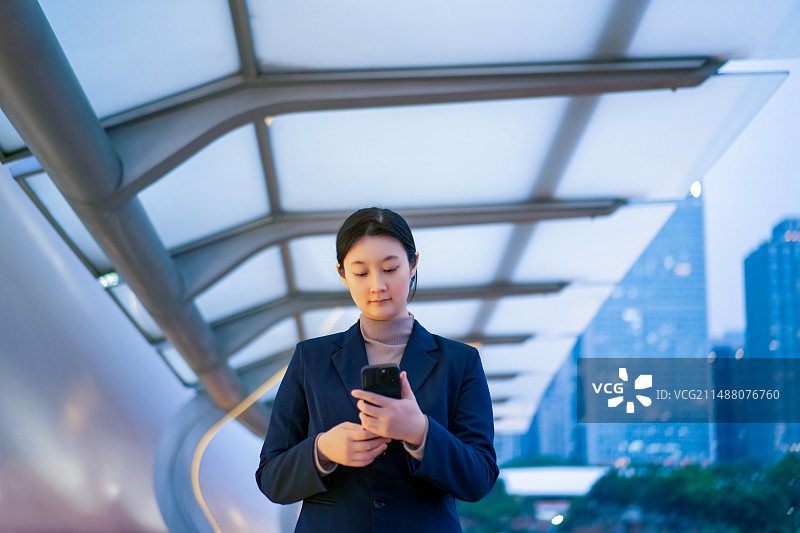 黄昏时使用智能手机的职业女性图片素材