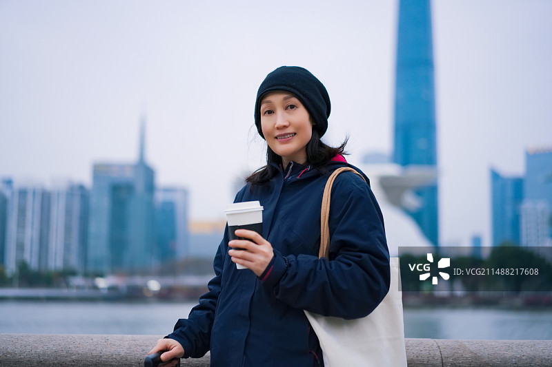 城市景观中享受咖啡的年轻女性图片素材