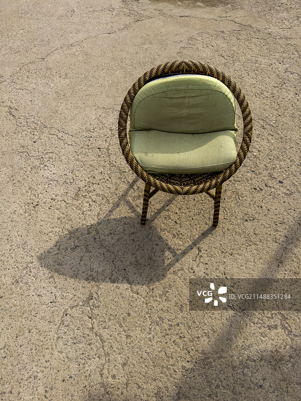 阳光下一把竹制带绿色坐垫的椅子图片素材
