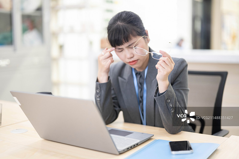 办公室职员取下眼镜揉眼睛图片素材