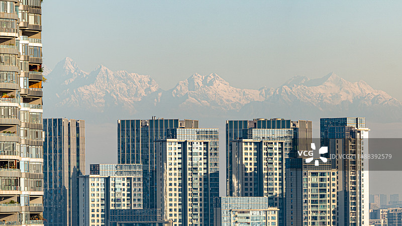 成都高新区的城市天际线和远处的雪山群峰图片素材