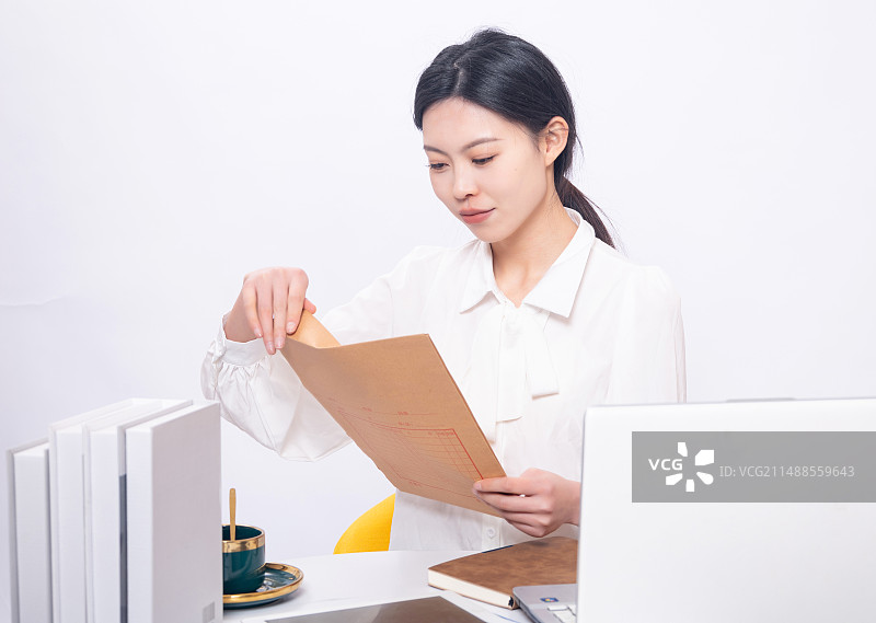 坐在白背景前的年轻女大学生形象手持文件夹图片素材