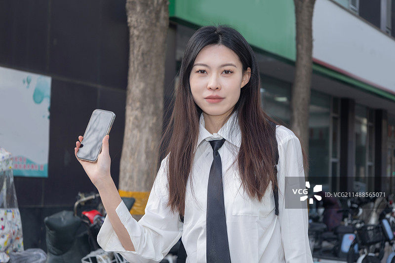 街头拿着手机的女学生图片素材
