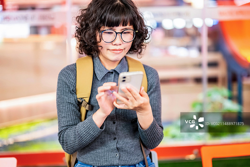 在餐厅外排队等位玩手机的女人图片素材