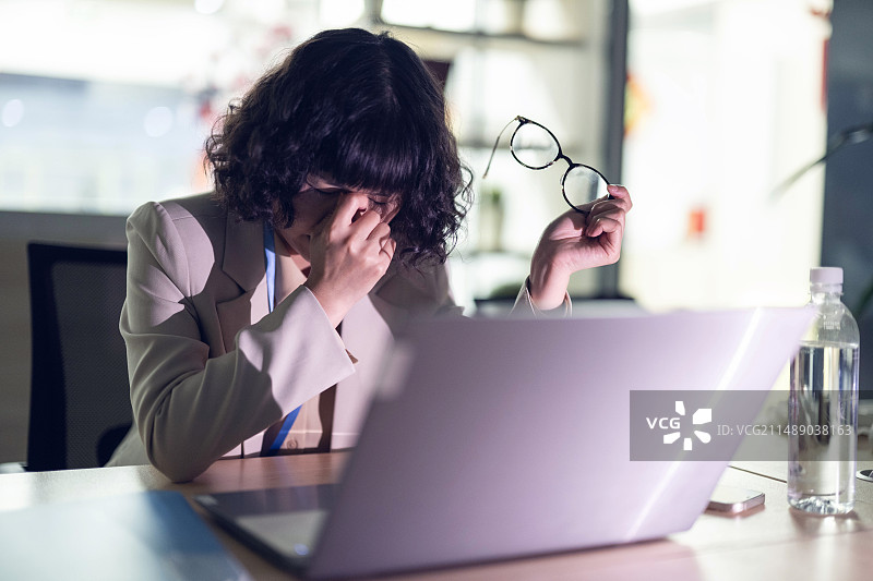 熬夜加班的白领取下眼镜揉眼睛图片素材