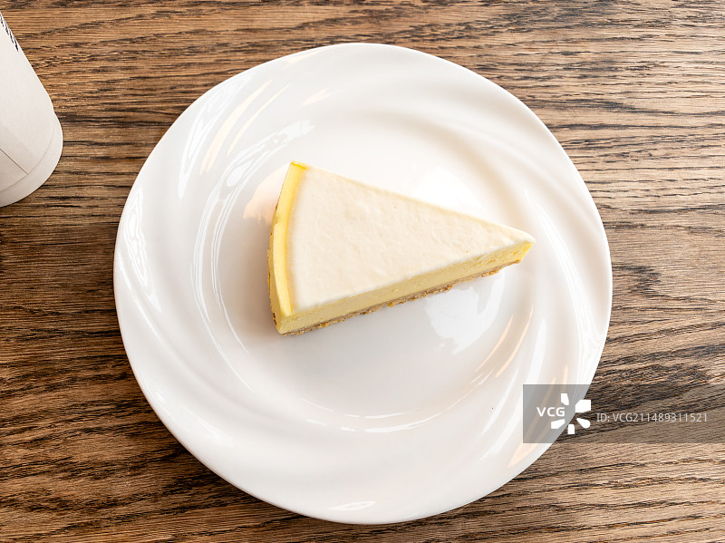 白色盘子装着的三角芝士蛋糕图片素材