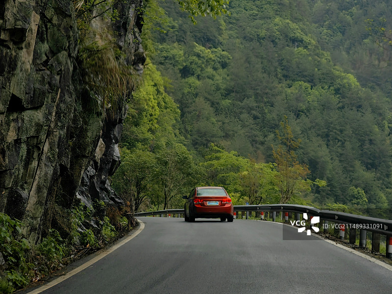 春季行驶在瓯江小溪边山区公路的红色汽车图片素材