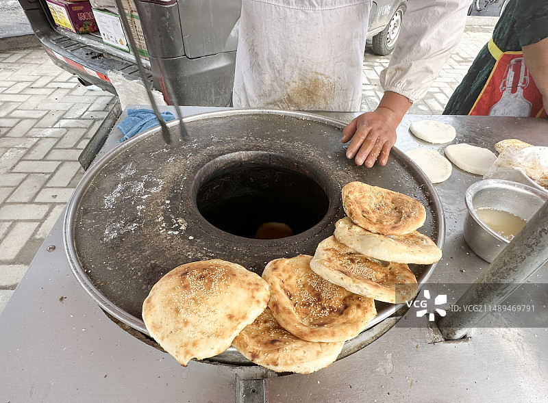 街边烧饼摊锅炉上摆放着几个刚出炉的芝麻烧饼图片素材