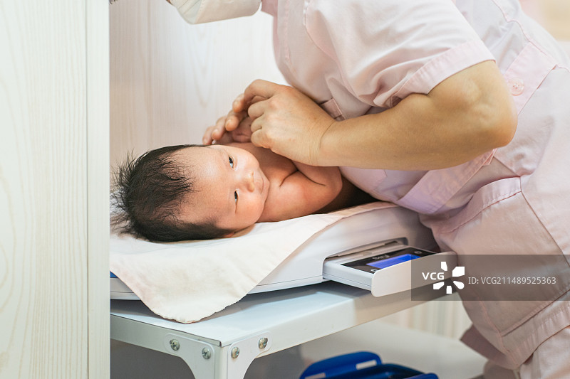月子中心,护士给新生儿做护理图片素材