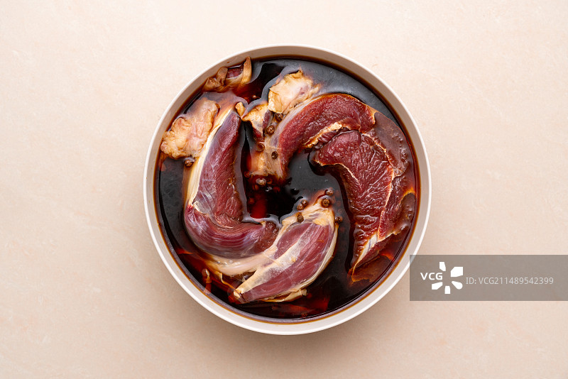 正上方白色背景的碗里的腌制中的肉图片素材