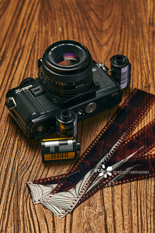 在木质桌板上的胶卷相机以及胶卷胶片图片素材
