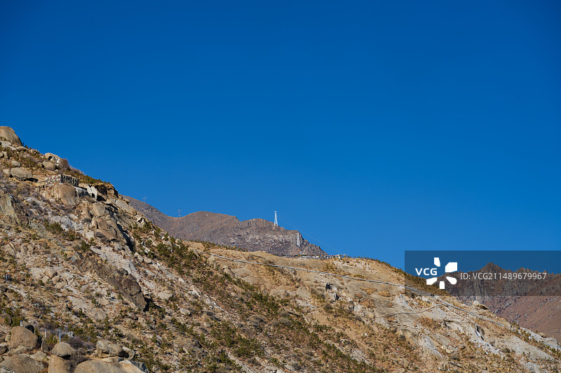 西藏拉萨晴朗冬季山顶上的电力输送塔图片素材