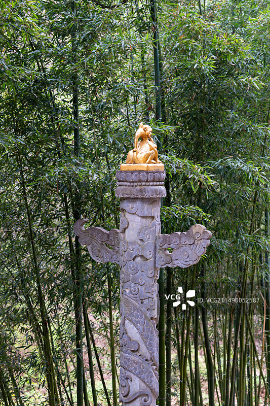 以绿色竹林为背景的刻有金色狮子的华表图片素材