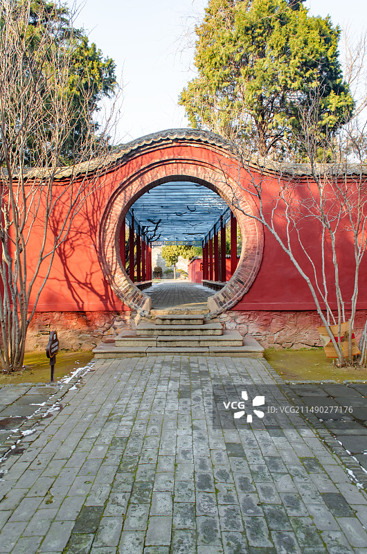 中国山东泰安著名景点泰山旅行旅游目的地风景区，泰山第一行宫岱庙，中式庭院里的月亮门和花坛，户外白昼无图片素材