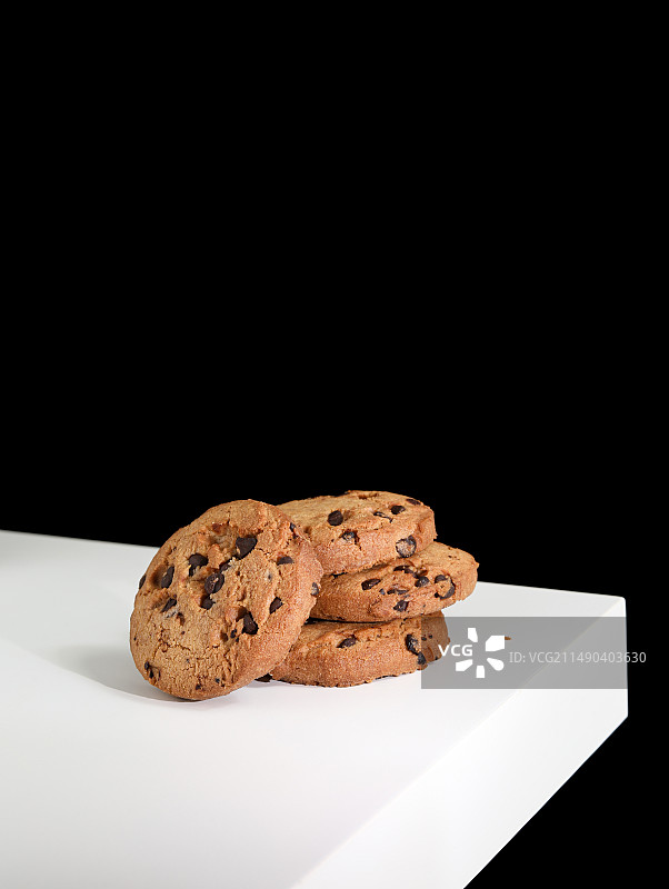 白色桌面上的一堆巧克力曲奇饼干图片素材