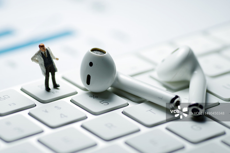 商务人士和键盘上的无线耳机图片素材