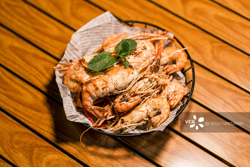 木桌上盘子里的罗氏虾特写镜头图片素材