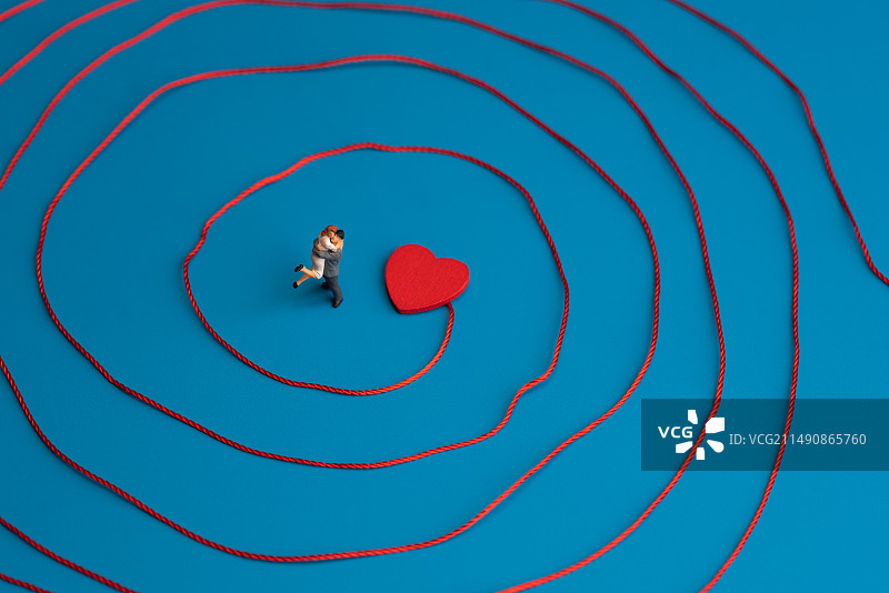 站在红线环绕内红心处拥抱的恋人微缩创意图片素材