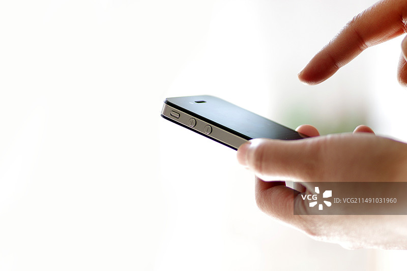 白色背景下手持智能手机的特写镜头图片素材